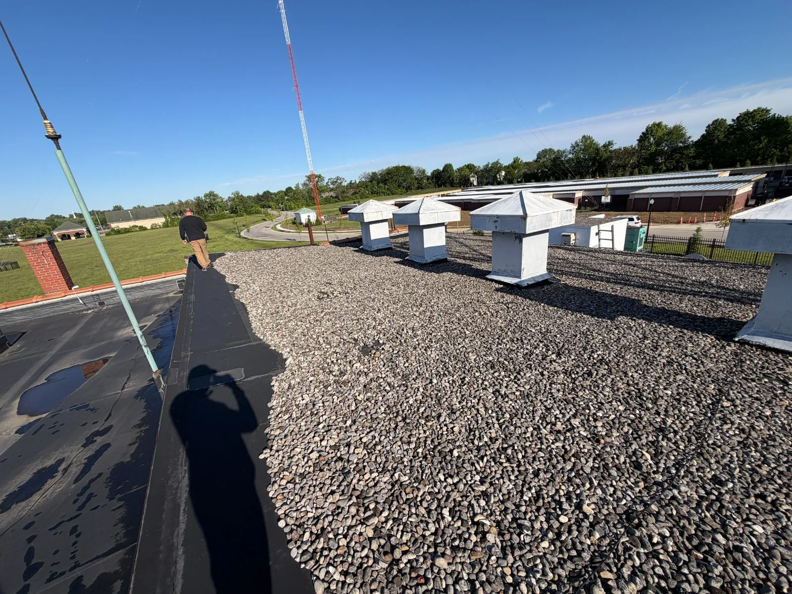 Gravel ballast covering a commercial roof at the WLW transmitter building, with vent housings visible