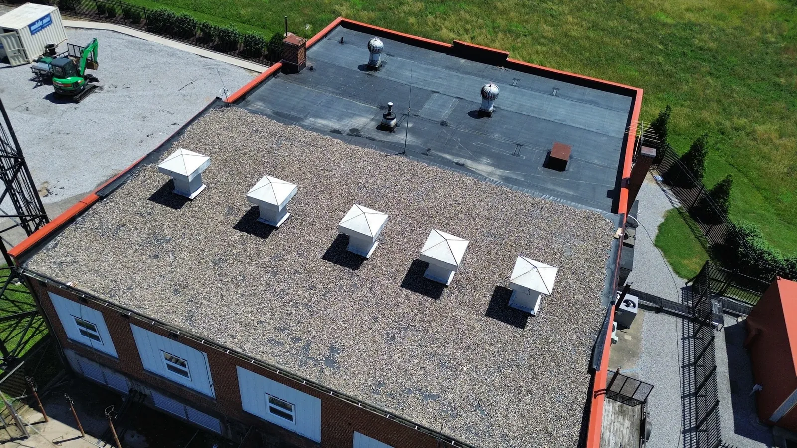 Aerial view of two roof areas at the historic WLW radio transmitter building in Mason, Ohio, one ballasted and one exposed EPDM membrane, with part of the broadcasting tower at left